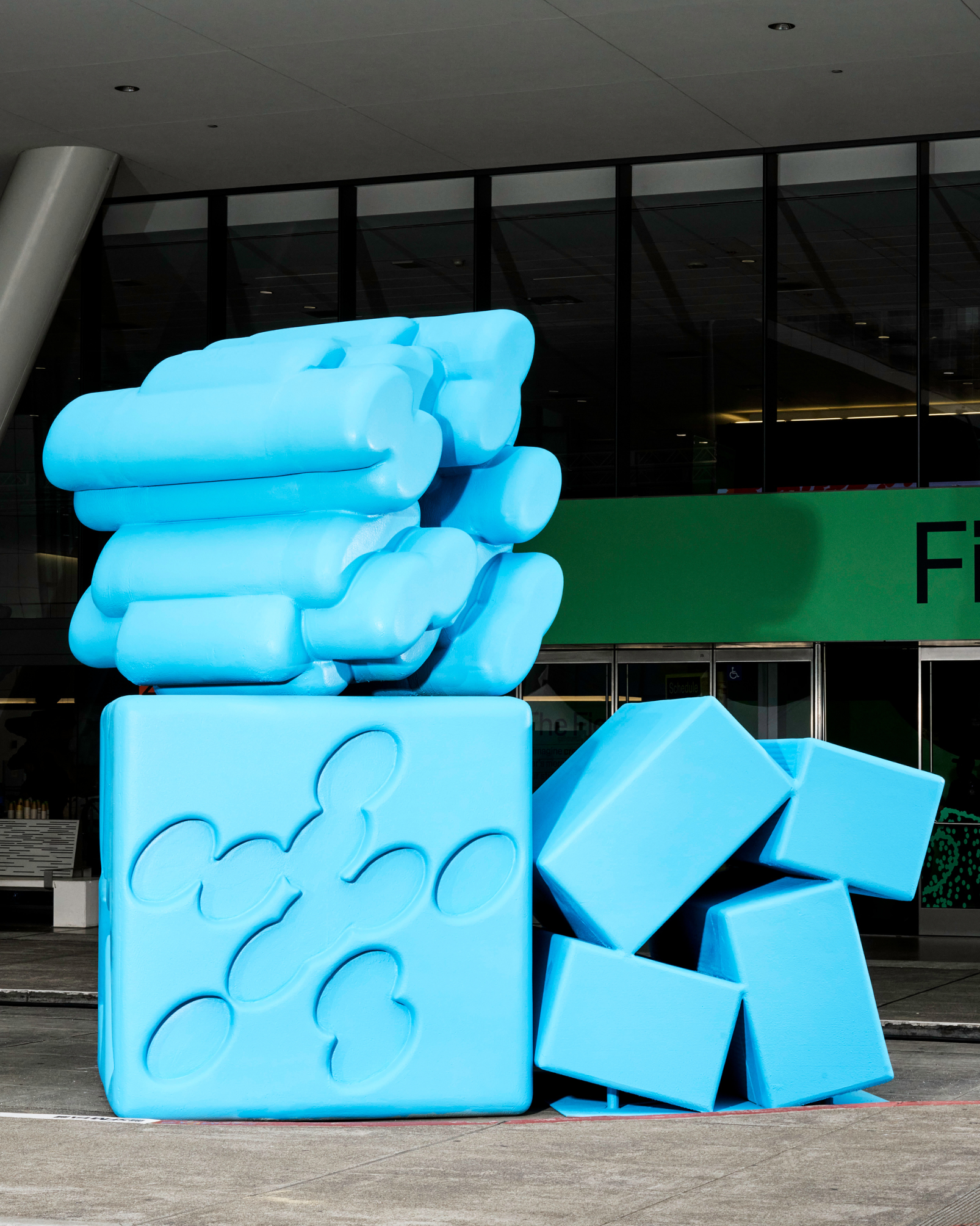 A large blue sculpture of three Config glyphs stacked and arranged outside Moscone 