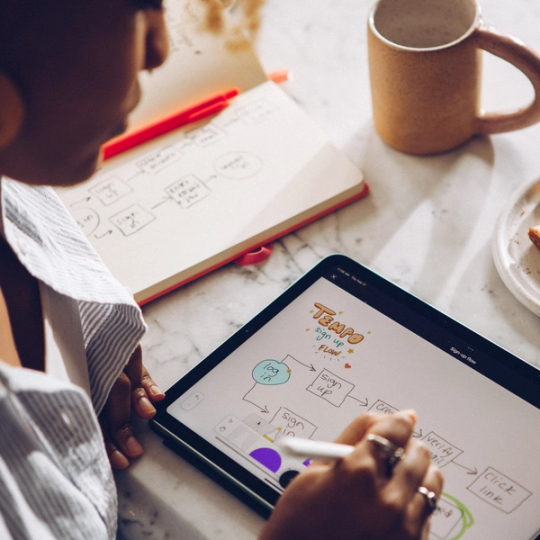 Person diagramming in FigJam using an iPad.