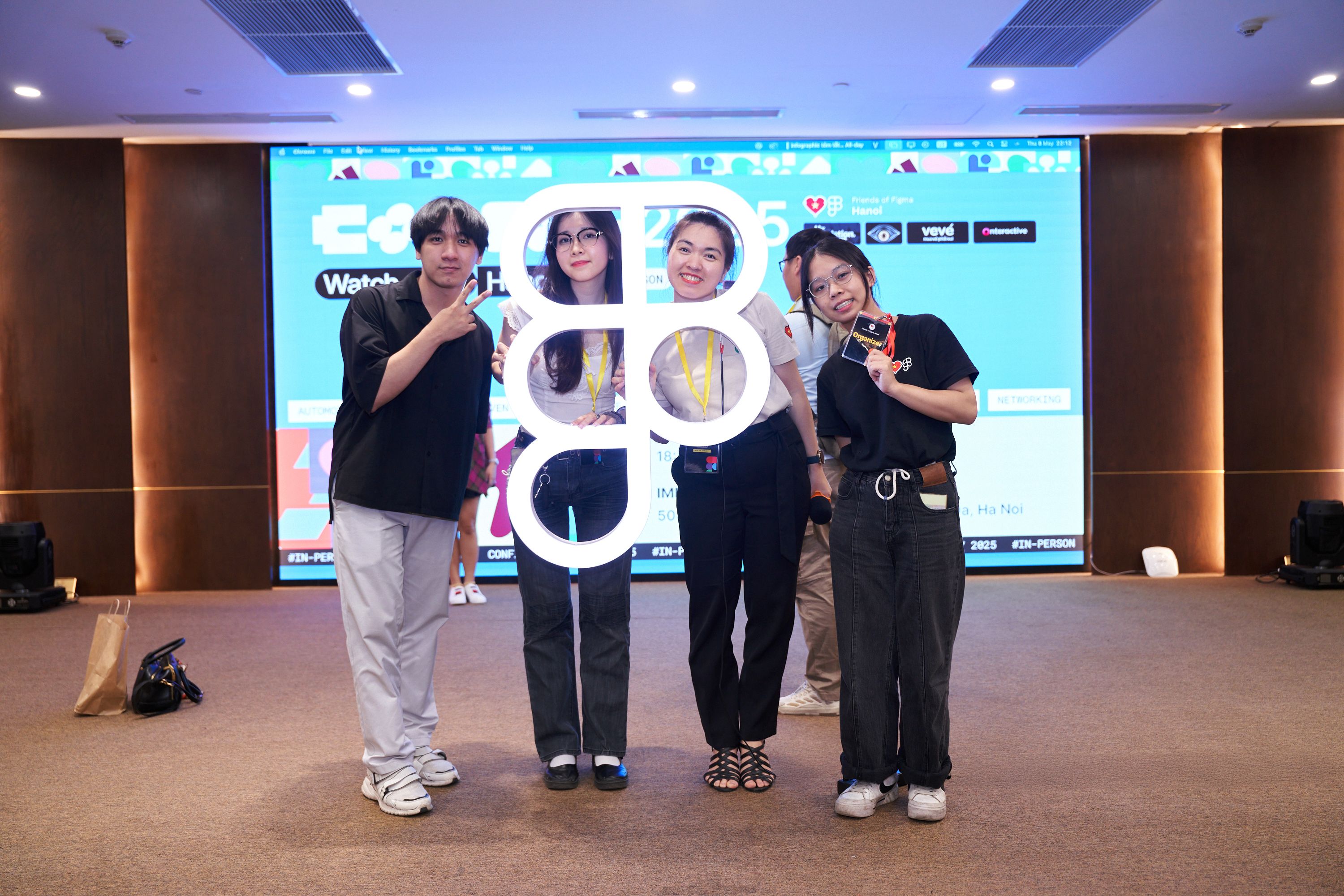 Individuals pose with a bright white, large Figma logo mark