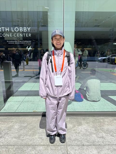 A woman wears a gray cap and lavender tracksuit