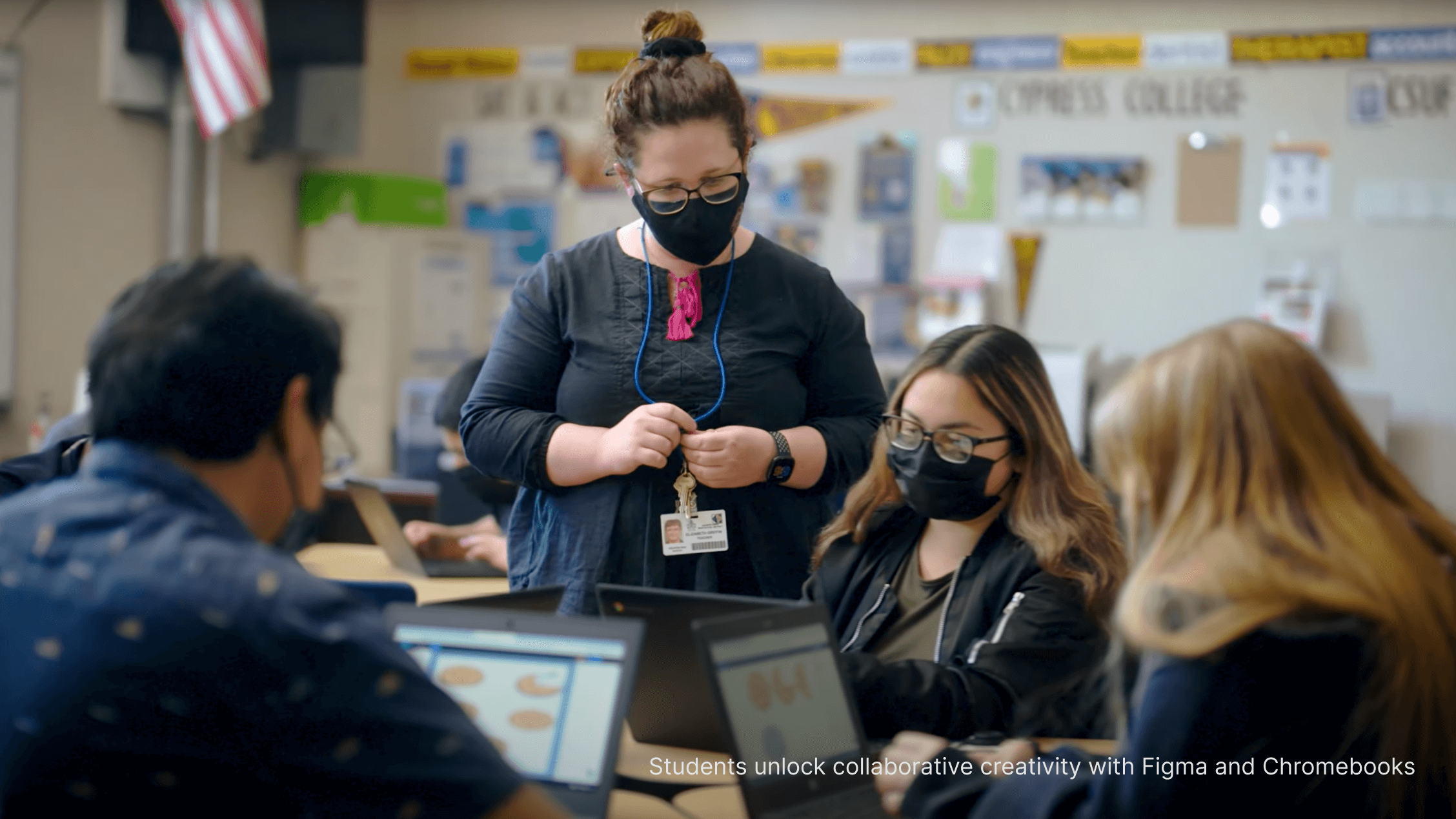 Four people grouped at a table on their laptops