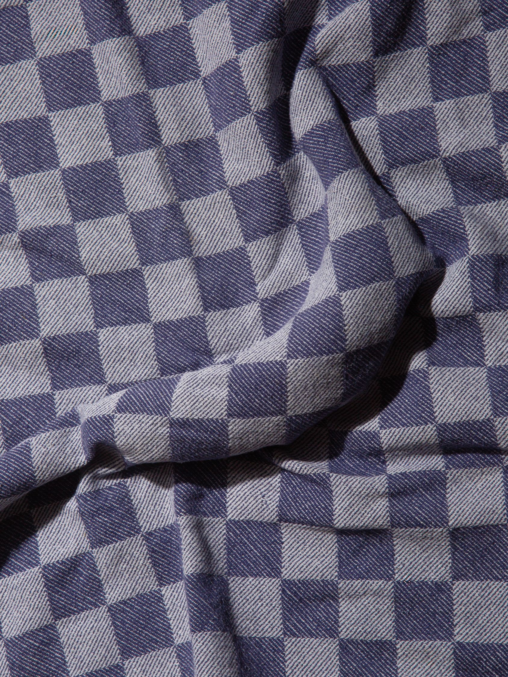 Blue-and-white geometric patterned fabric draped in soft folds.