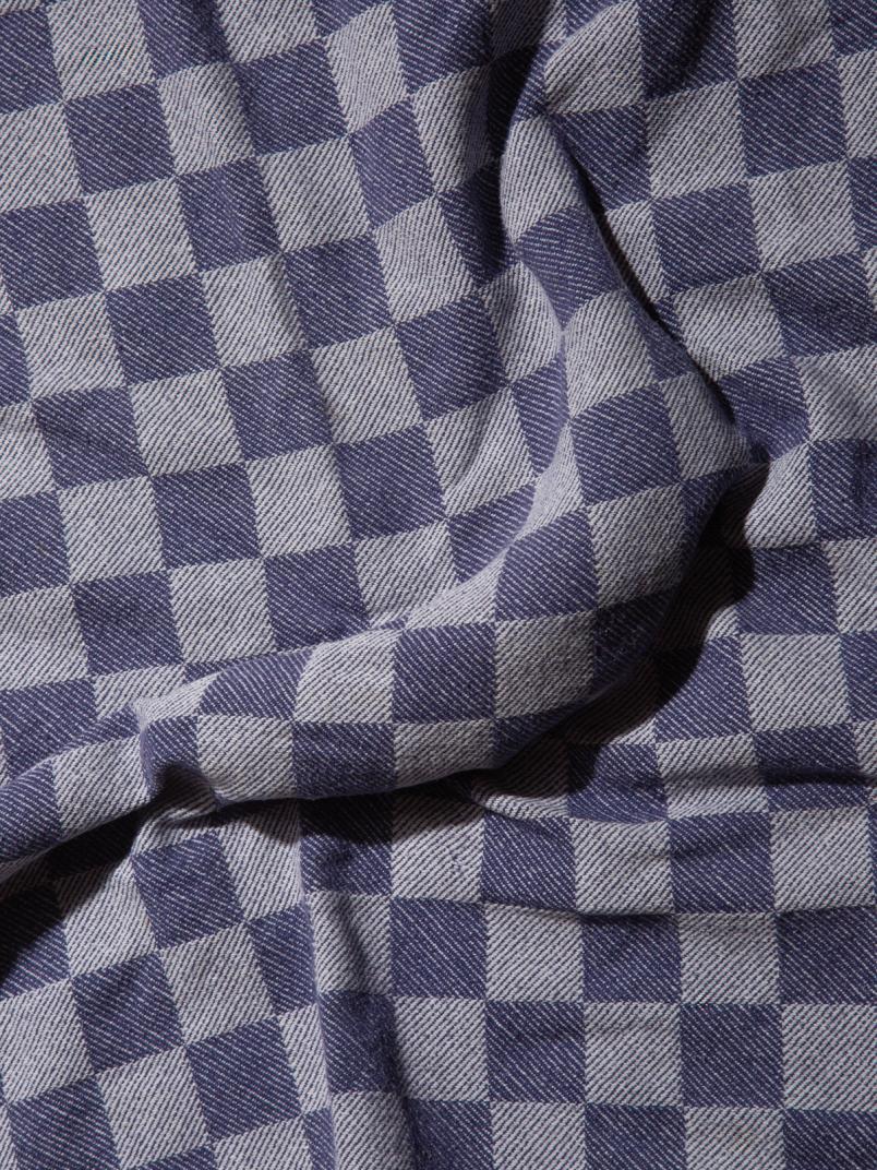 Blue-and-white geometric patterned fabric draped in soft folds.