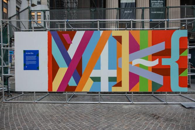 A mural spelling “MAKE” using bold colors and code-inspired shapes.
