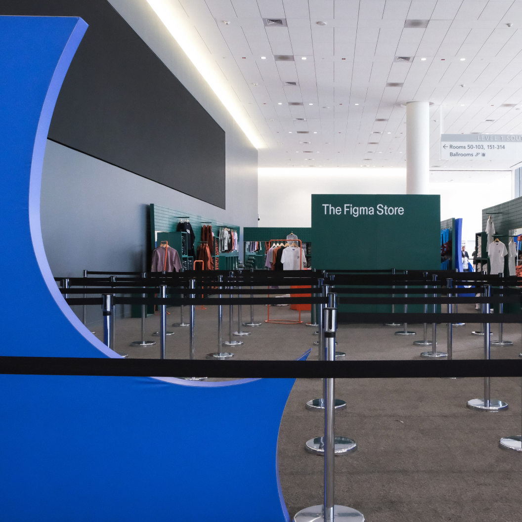 Empty queue area leads to The Figma Store inside a bright, modern conference interior.