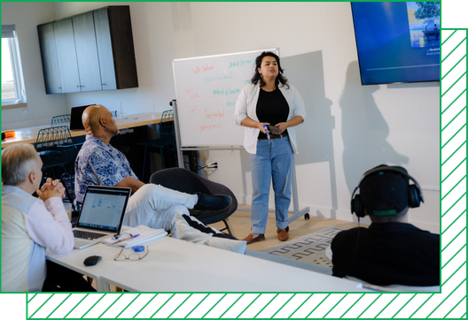 Instructor Alexis Bustos stands in front of a whiteboard in class