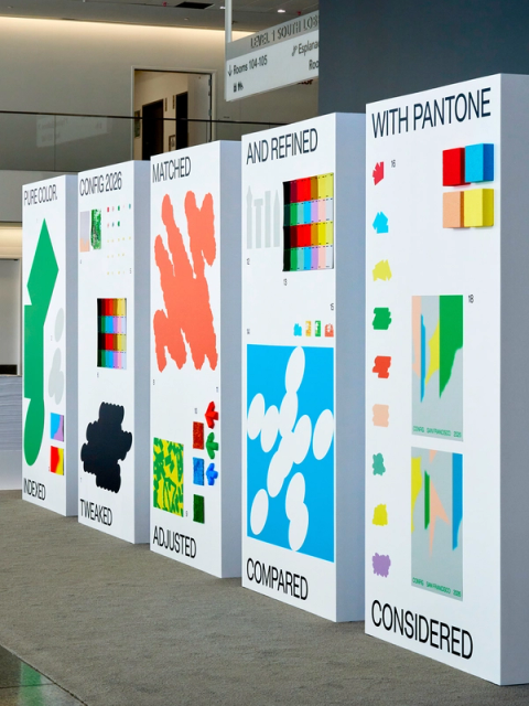 A row of tall gallery walls display color swatches, samples, glyphs, and other materials