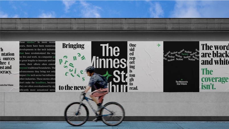 A photograph of a cyclist passing a series of rebranded Minnesota Star Tribune posters.