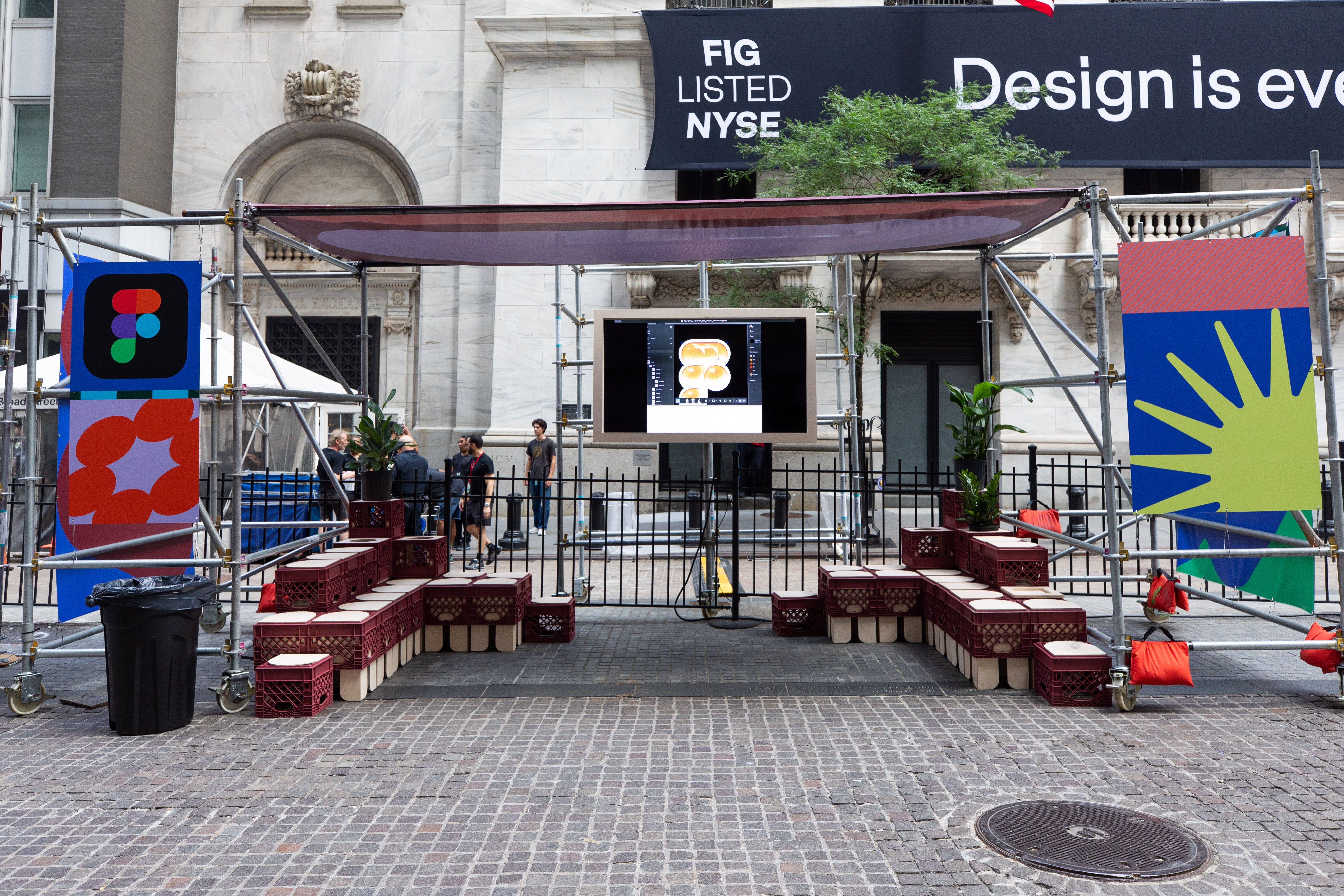 A small stage area with crate seating and a screen set up outside the NYSE.