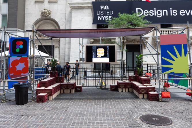 A small stage area with crate seating and a screen set up outside the NYSE.