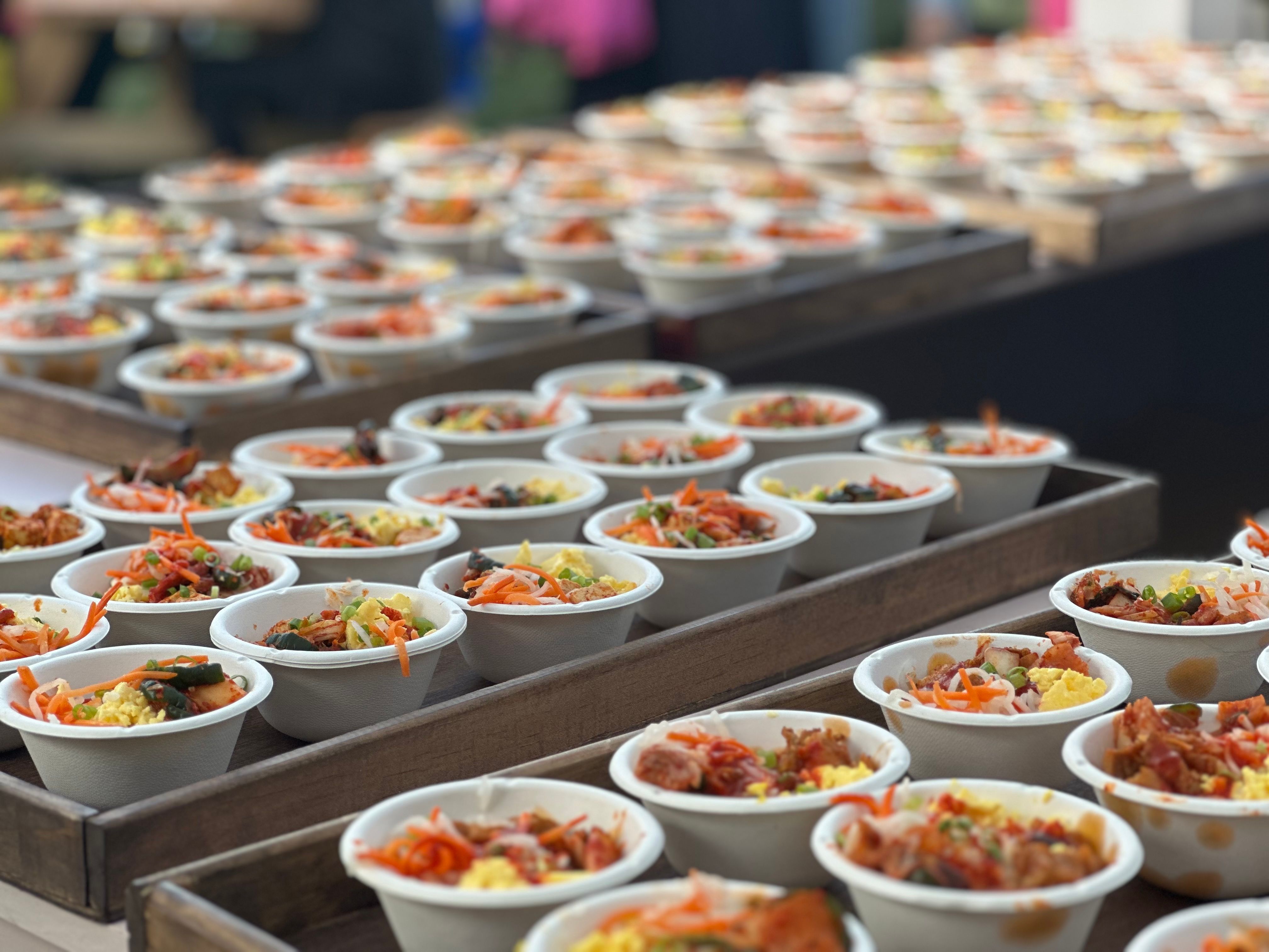 Bowls of Korean rice bowls topped with veggies and pork belly.