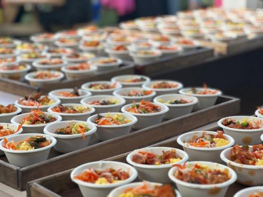 Bowls of Korean rice bowls topped with veggies and pork belly.