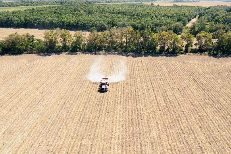A photograph shows a bird's eye view of a tractor spreading rock powder over crops