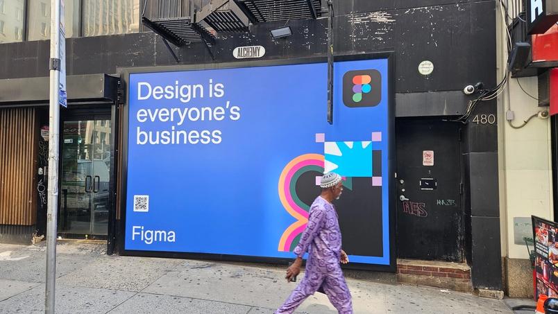 Large blue Figma billboard on a black storefront at 480 Broadway with the text “Design is everyone’s business” and colorful graphic elements.