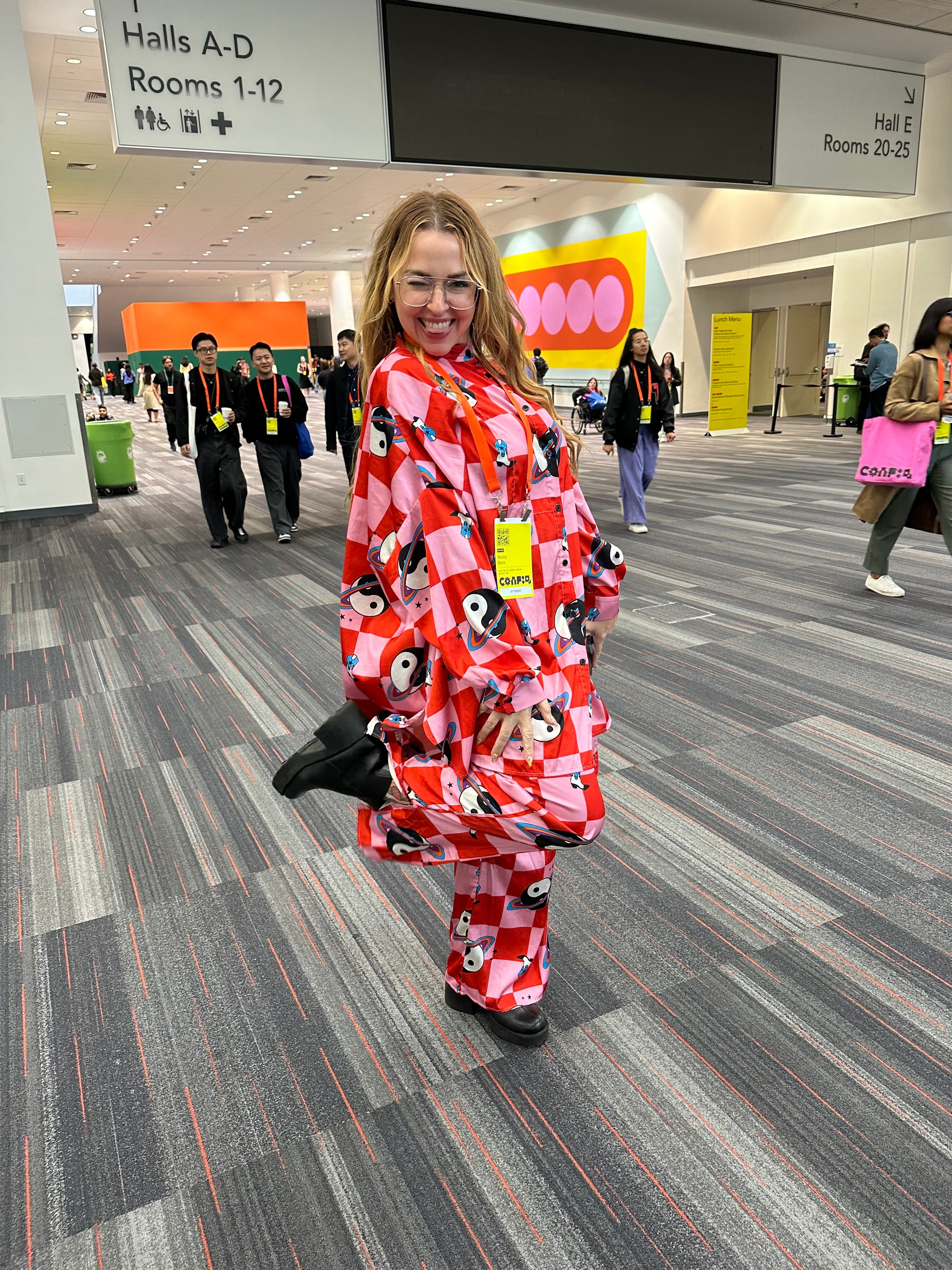 A woman wears a red and pink checkered shirt and pants set with an overlaid yin yang print
