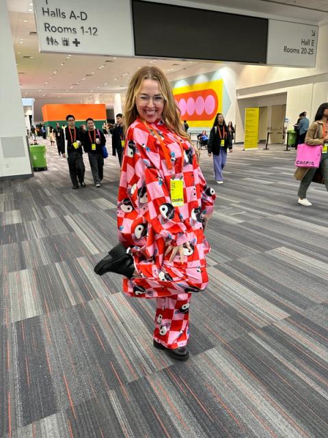 A woman wears a red and pink checkered shirt and pants set with an overlaid yin yang print