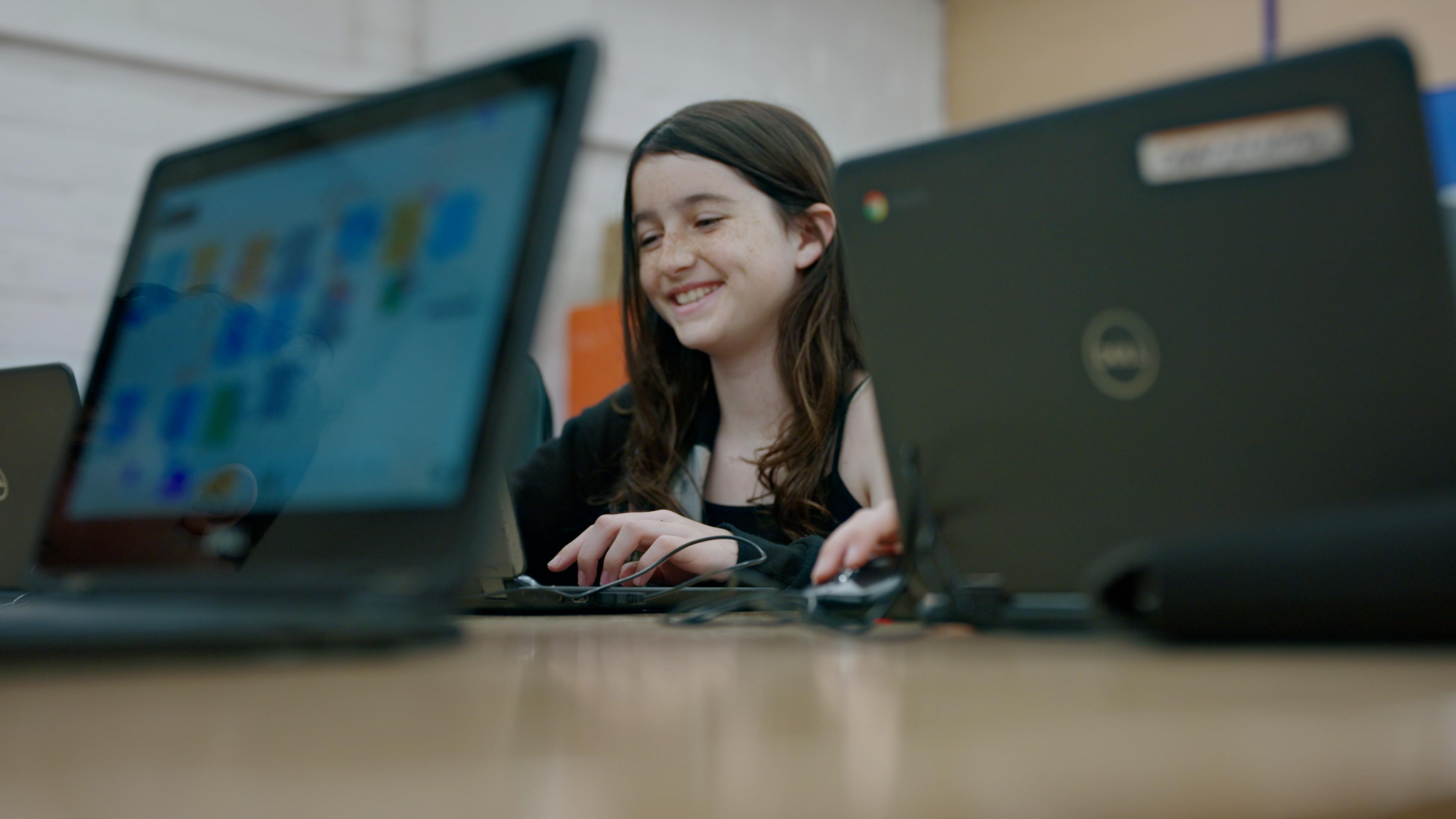 a young child on a laptop smiling
