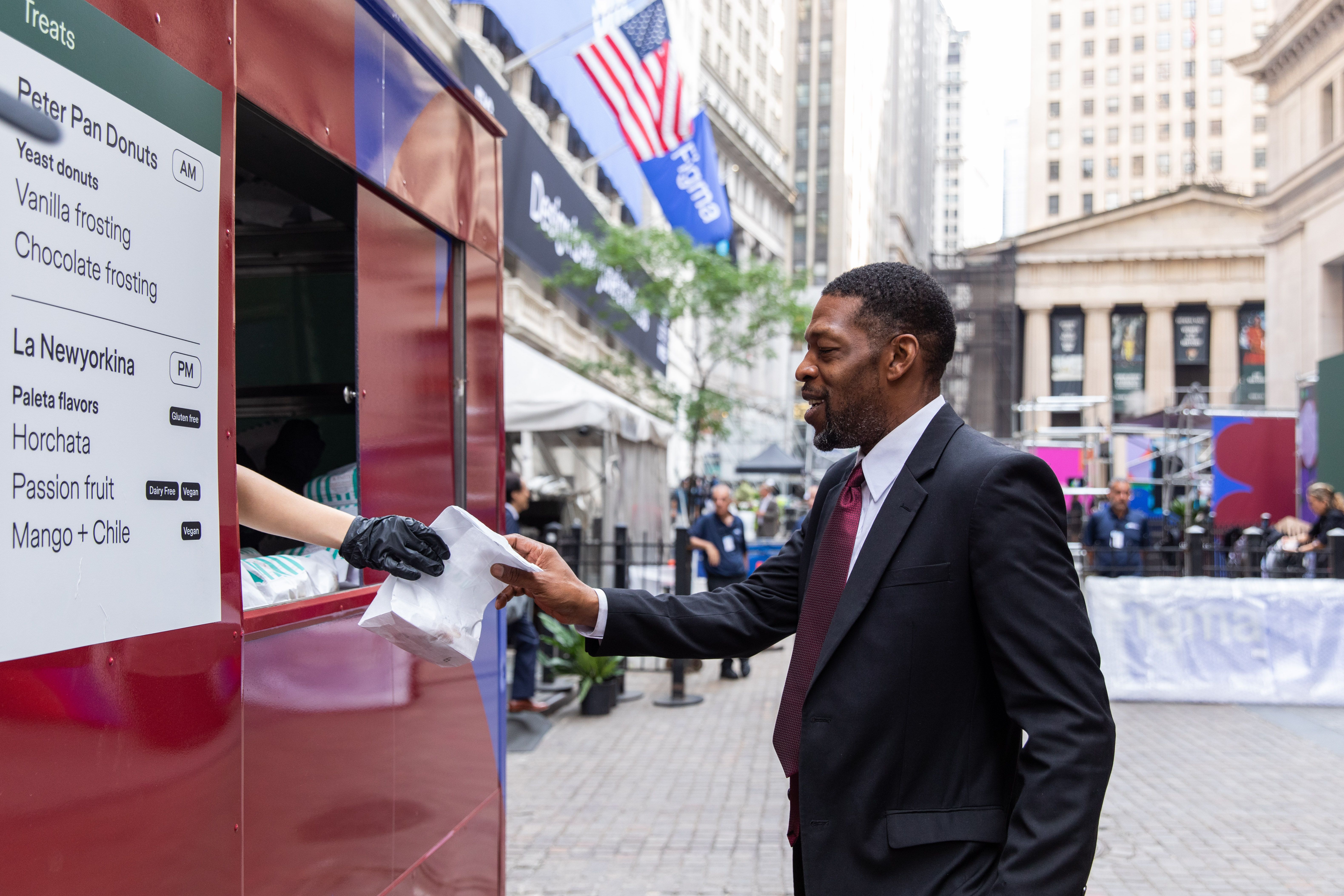 A man receives food from a red truck near the NYSE during the event.