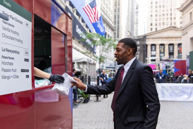 A man receives food from a red truck near the NYSE during the event.