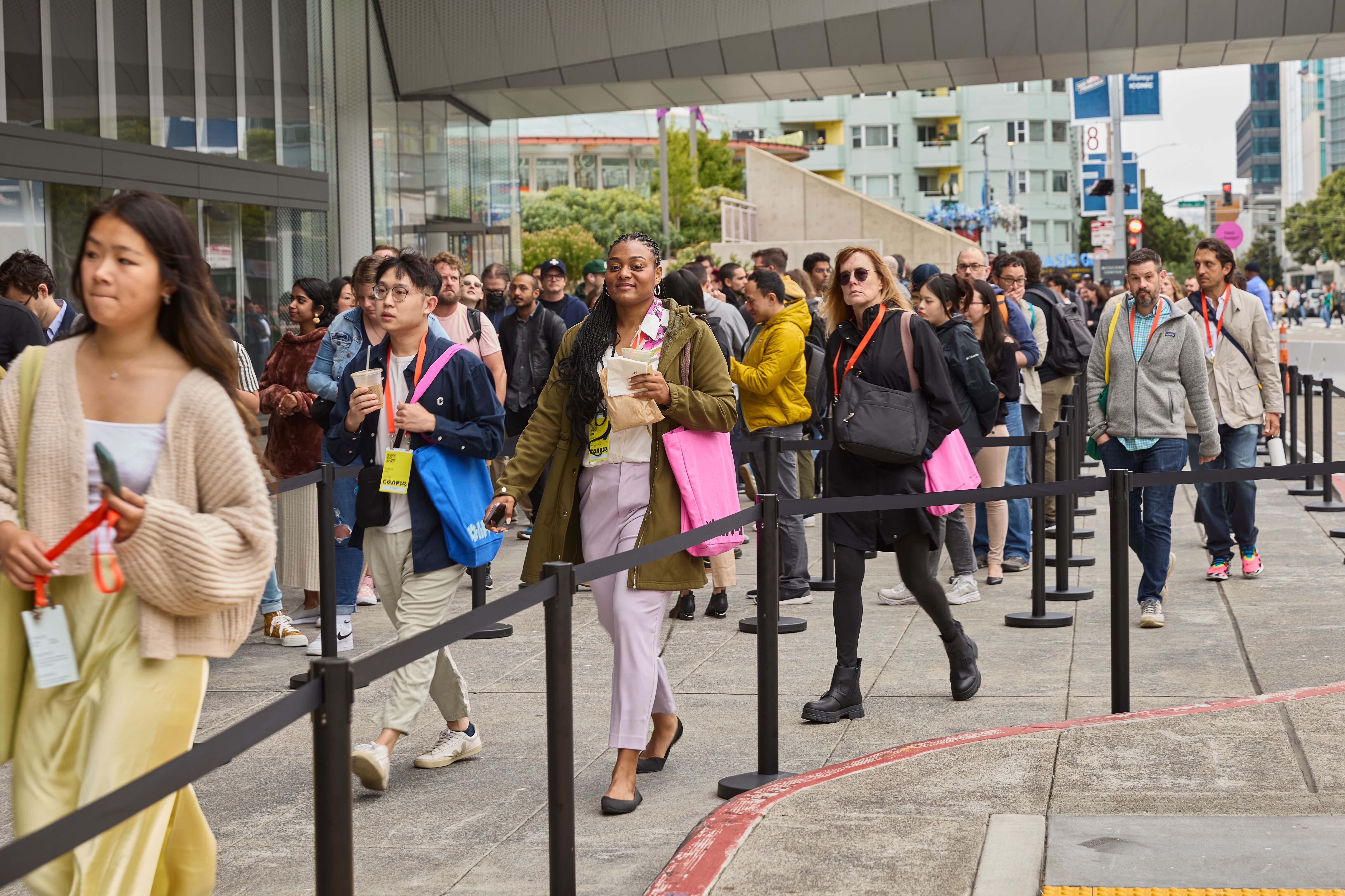 A crowd of conference attendees walk on the sidewalk outside Moscone Center.