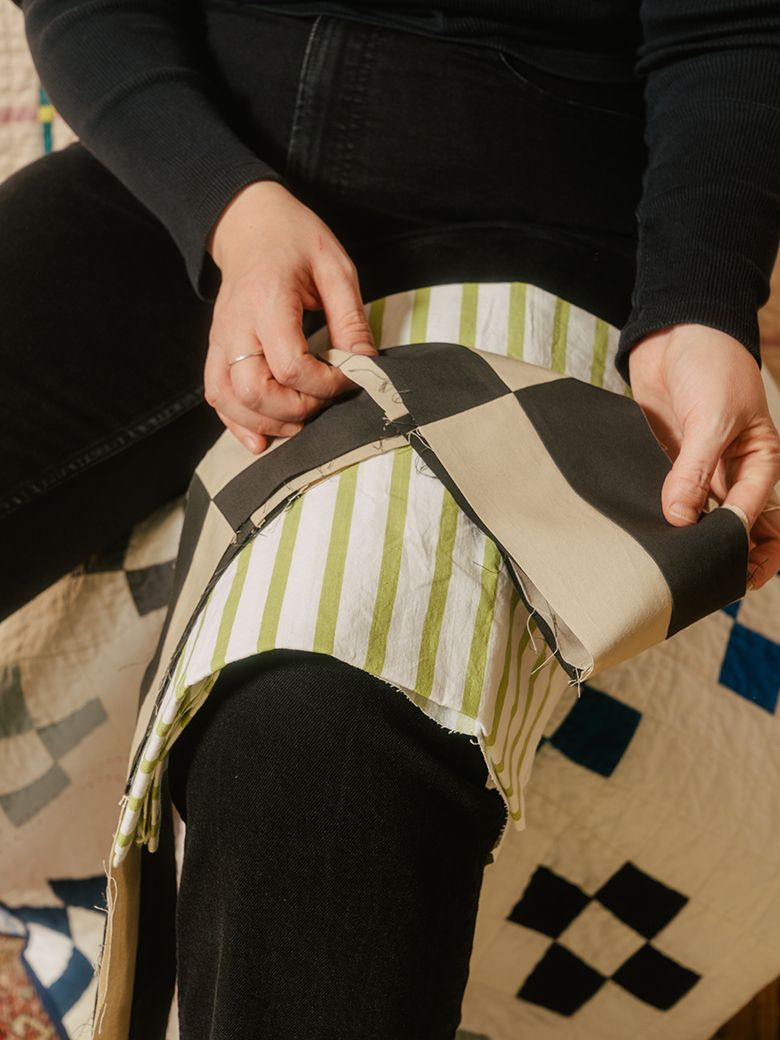 A photograph of a black and tan fabric folded over Nicole’s knee.