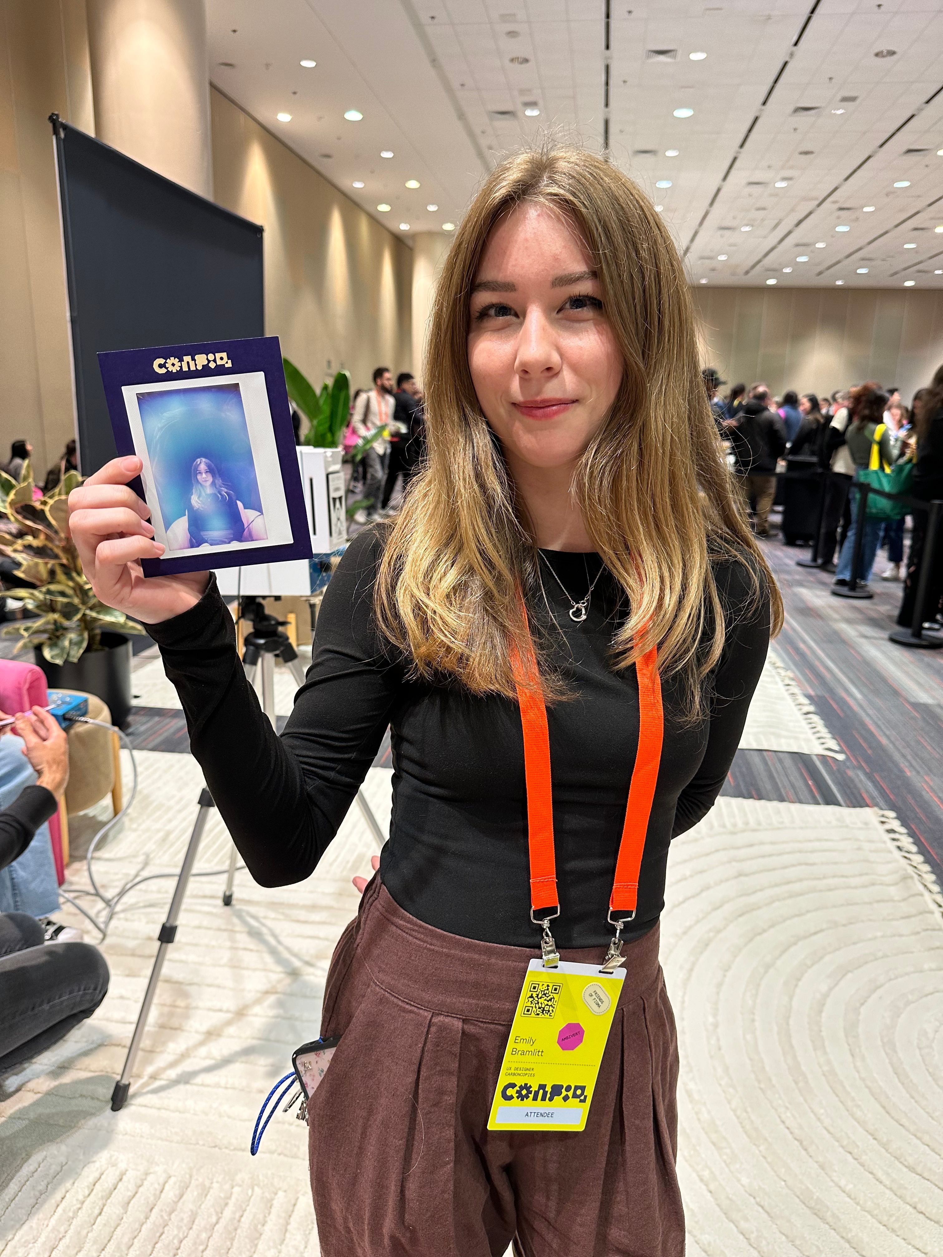 A woman holds up an aura portrait, which shows a blue halo.