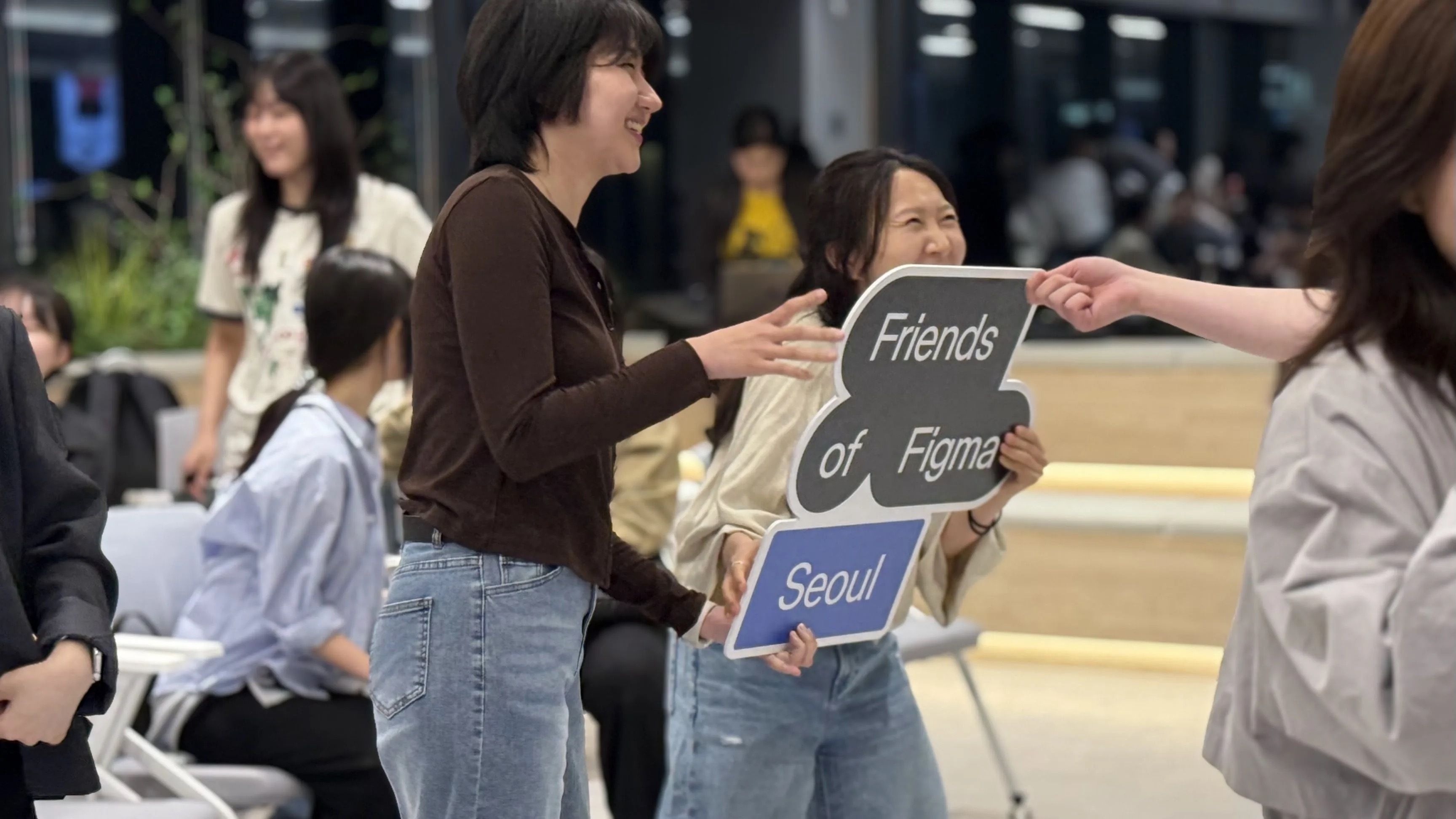 Attendees in Seoul hold large Friends of Figma Seoul sign while smiling
