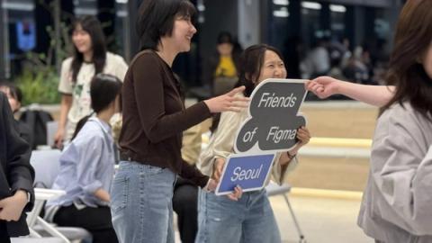 Attendees in Seoul hold large Friends of Figma Seoul sign while smiling
