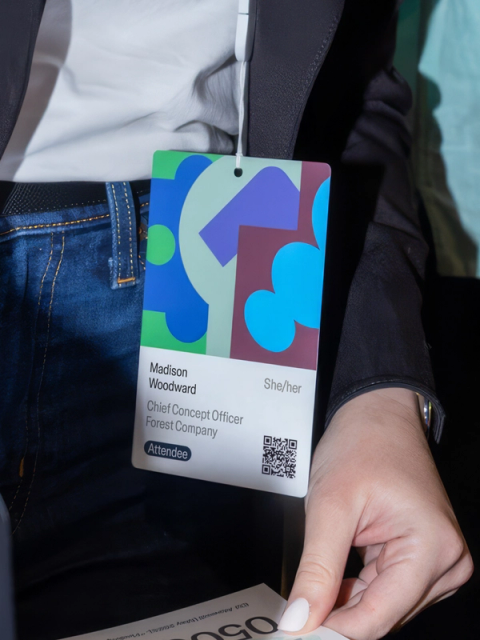 Config attendee badge for Madison Woodward, decorated with geometric shapes and pronouns shown.