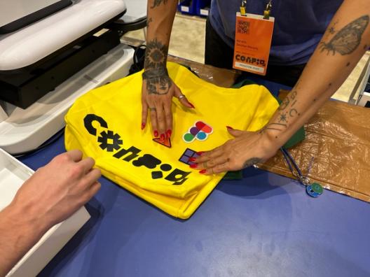 Hands arrange Figma patches on a yellow Config tote.