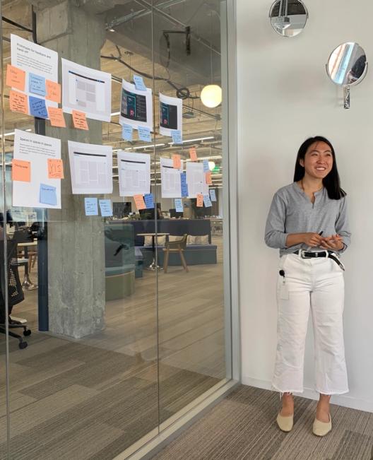 person standing next to stickies on a glass wall