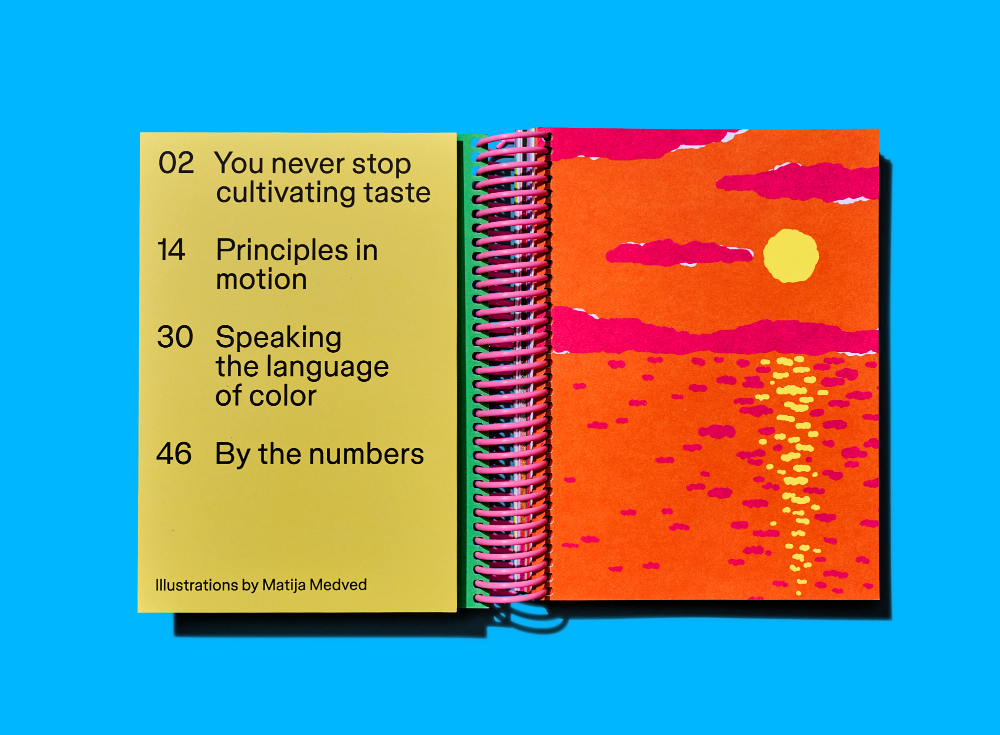 Colorful table of contents sits beside a vibrant sunset illustration across an open notebook spread.