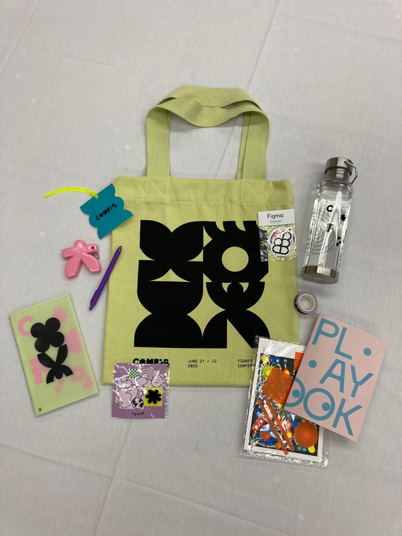 A photo capturing some of the Config swag including a tote bag, water bottle, and zine.