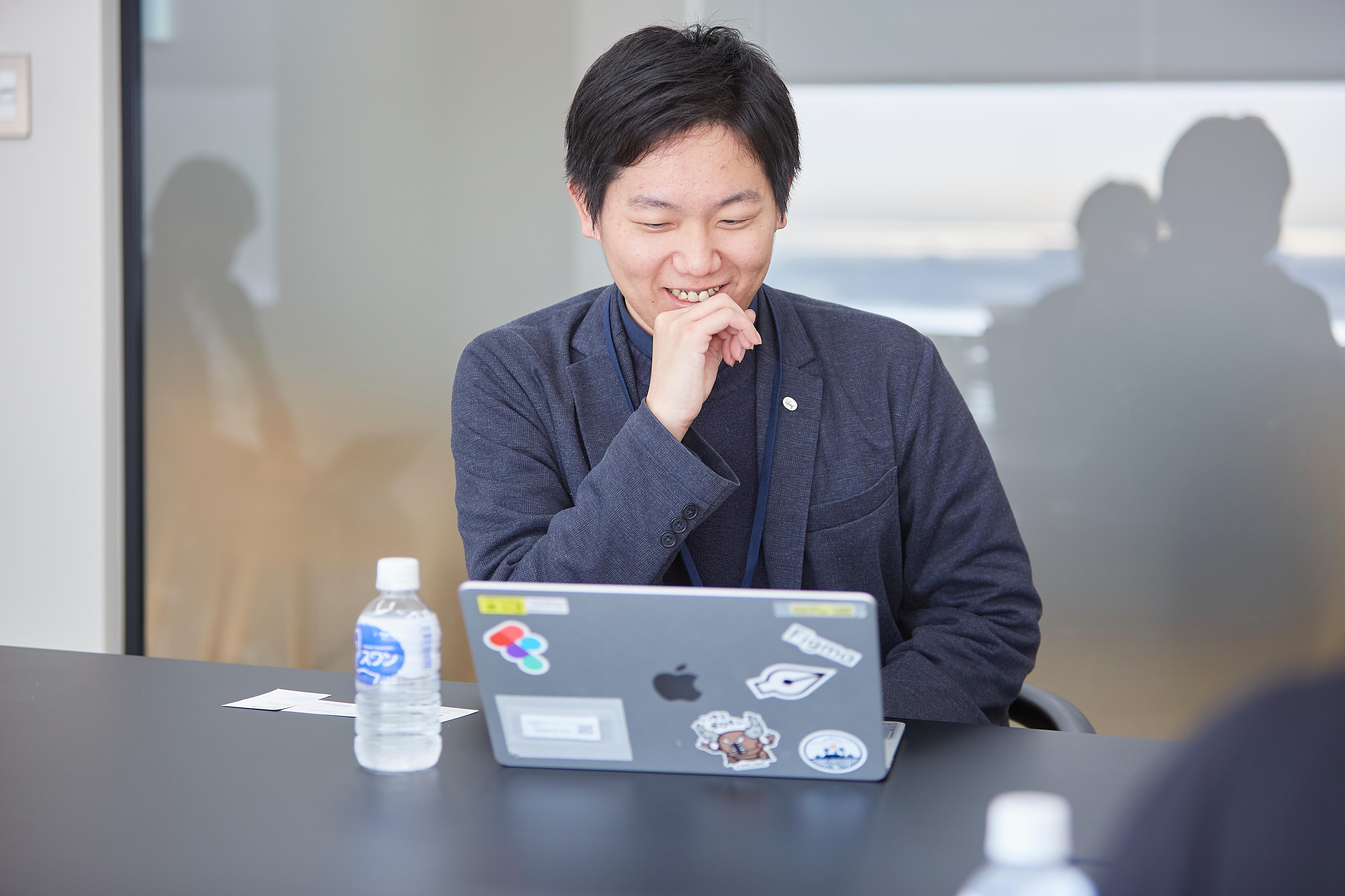 Figmaのロゴが張られたPCを愛用する堤氏
