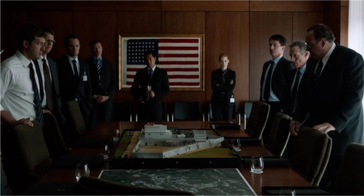 Officials gather around a table model of a compound in Zero Dark Thirty.