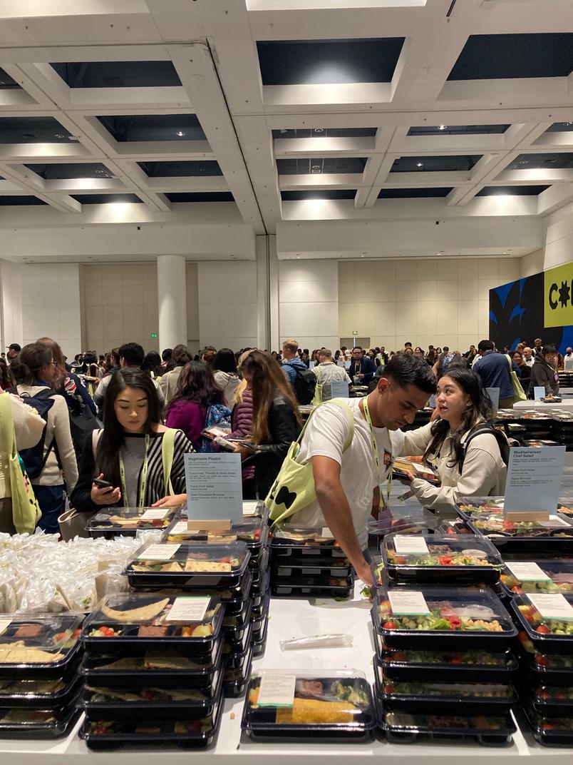 People pick up box lunches in Config’s food hall.
