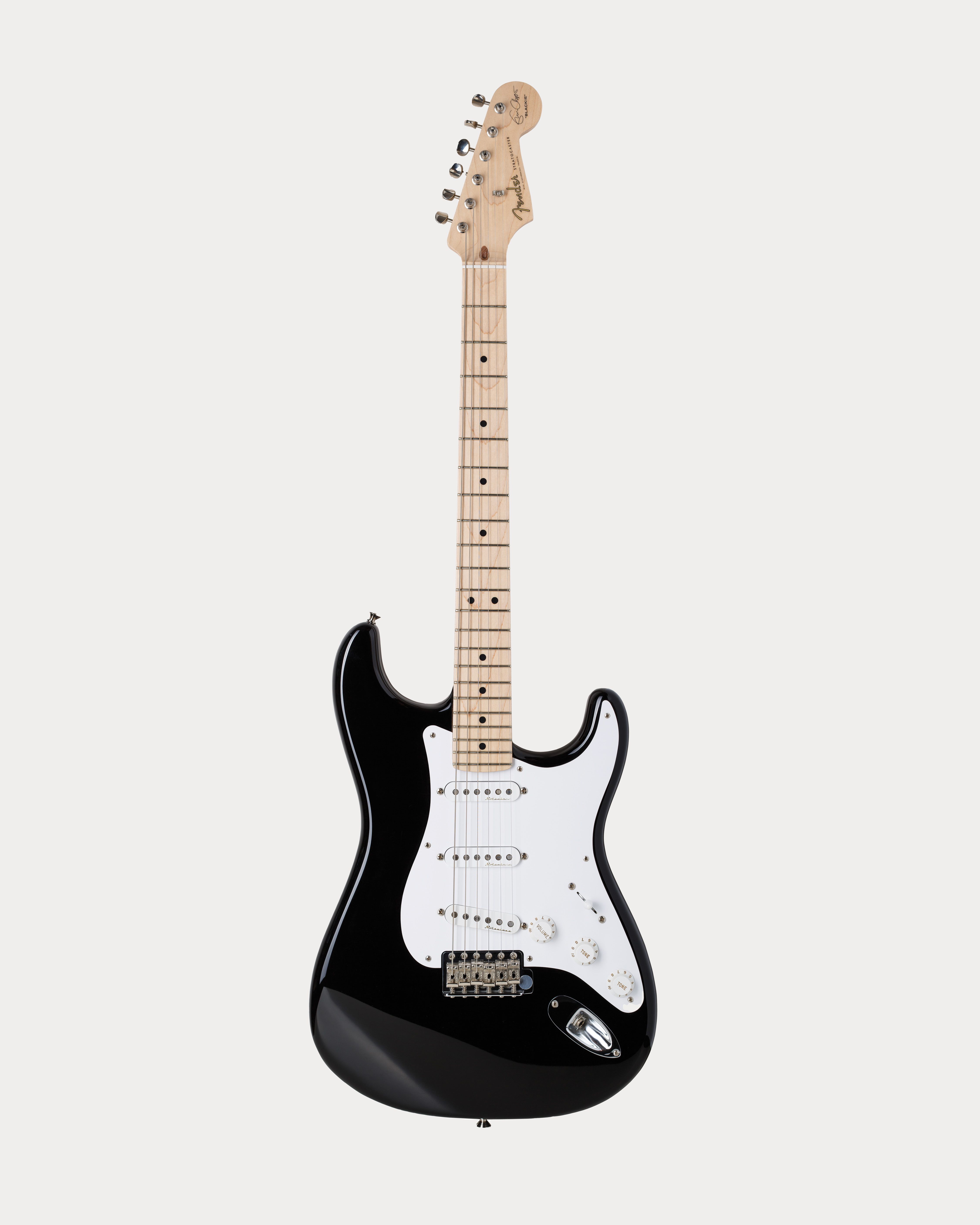 A black electric guitar with a white pickguard and light-colored neck, featuring six strings and three pickups, set against a plain white background.