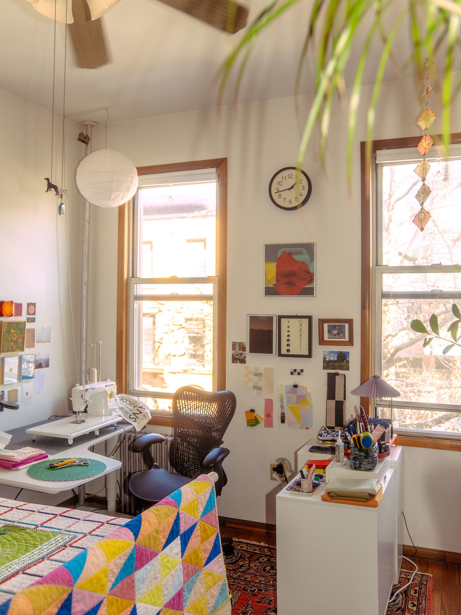 A photograph shows Nicole’s white desk, which holds her laptop and sewing machine. Artwork, color studies, and other inspiration dot her walls.