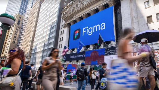 Crowds gather outside the New York Stock Exchange under a large Figma banner during the Figma Commons event.