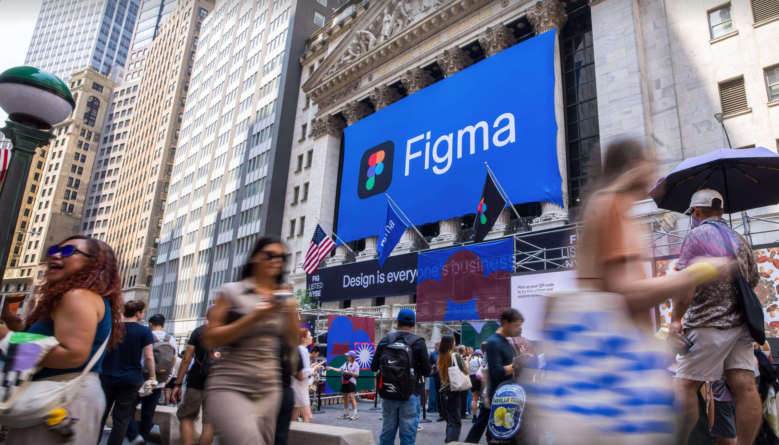 Crowds gather outside the New York Stock Exchange under a large Figma banner during the Figma Commons event.