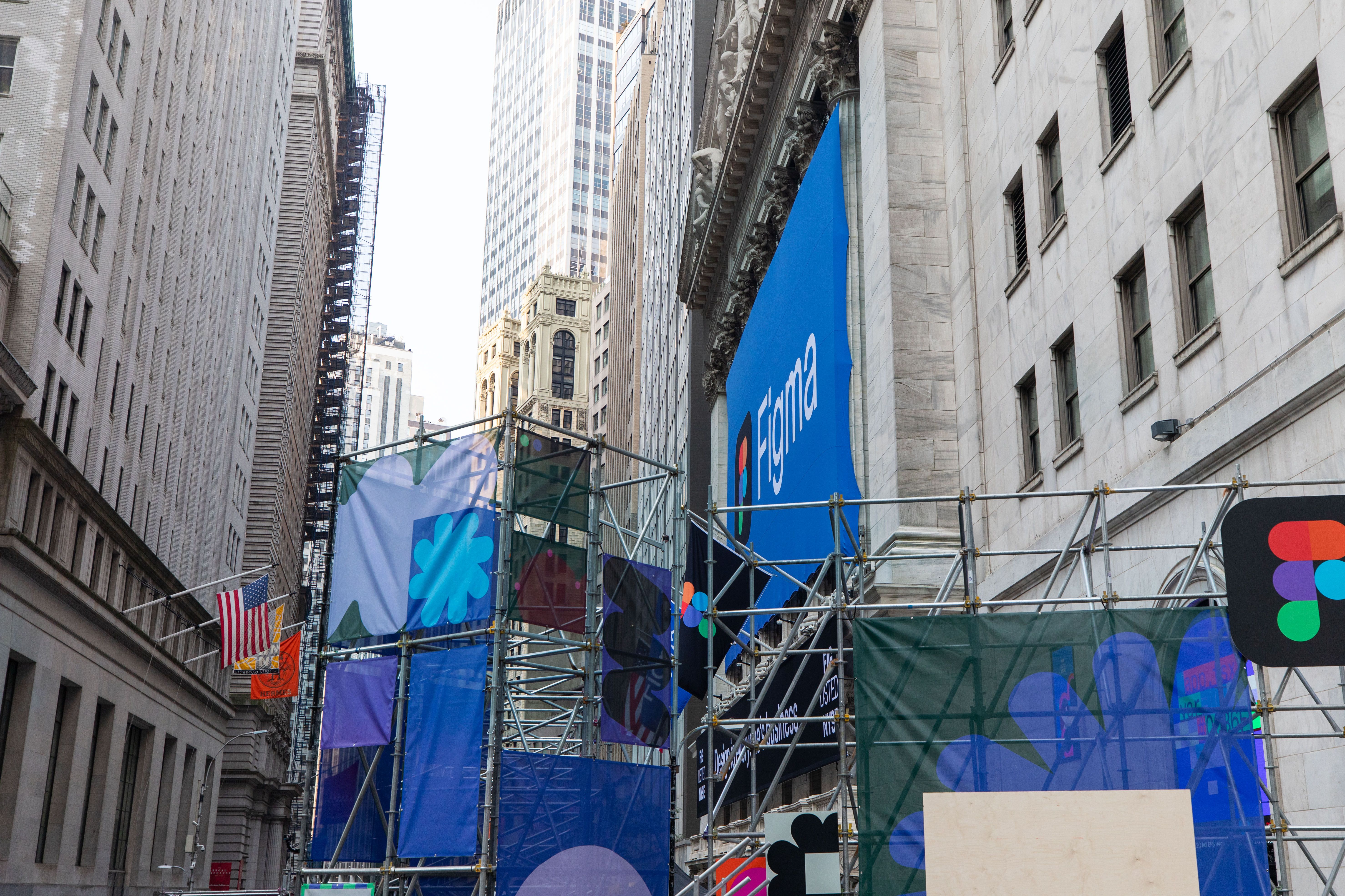 Scaffolding wrapped in colorful graphic panels outside the New York Stock Exchange with a large Figma banner above the entrance.