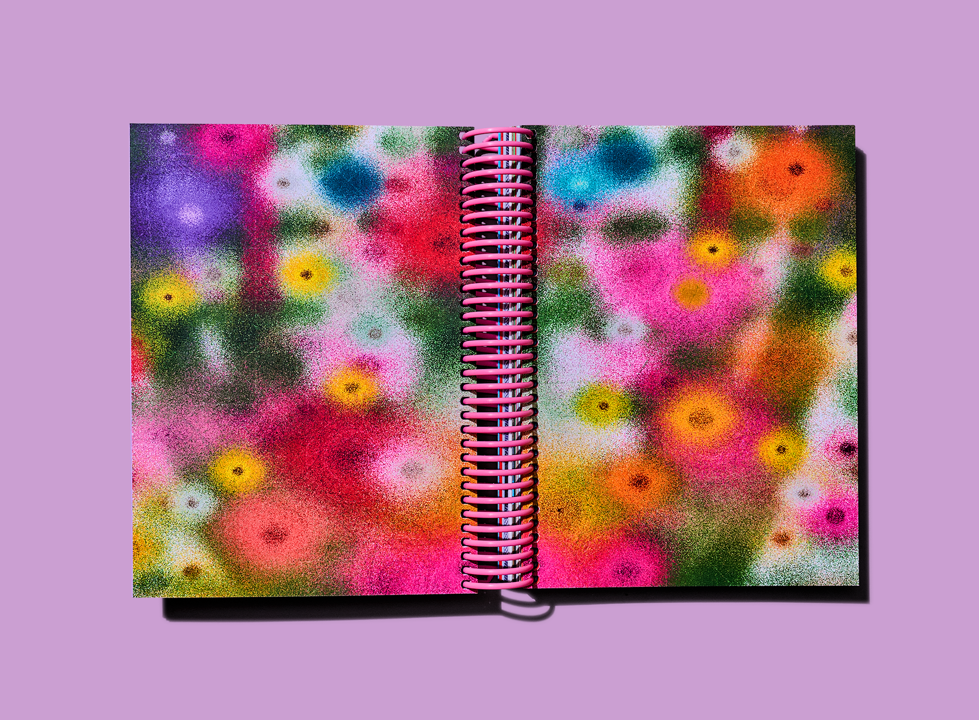 Full-bleed abstract floral artwork fills both pages of an open spiral-bound notebook.