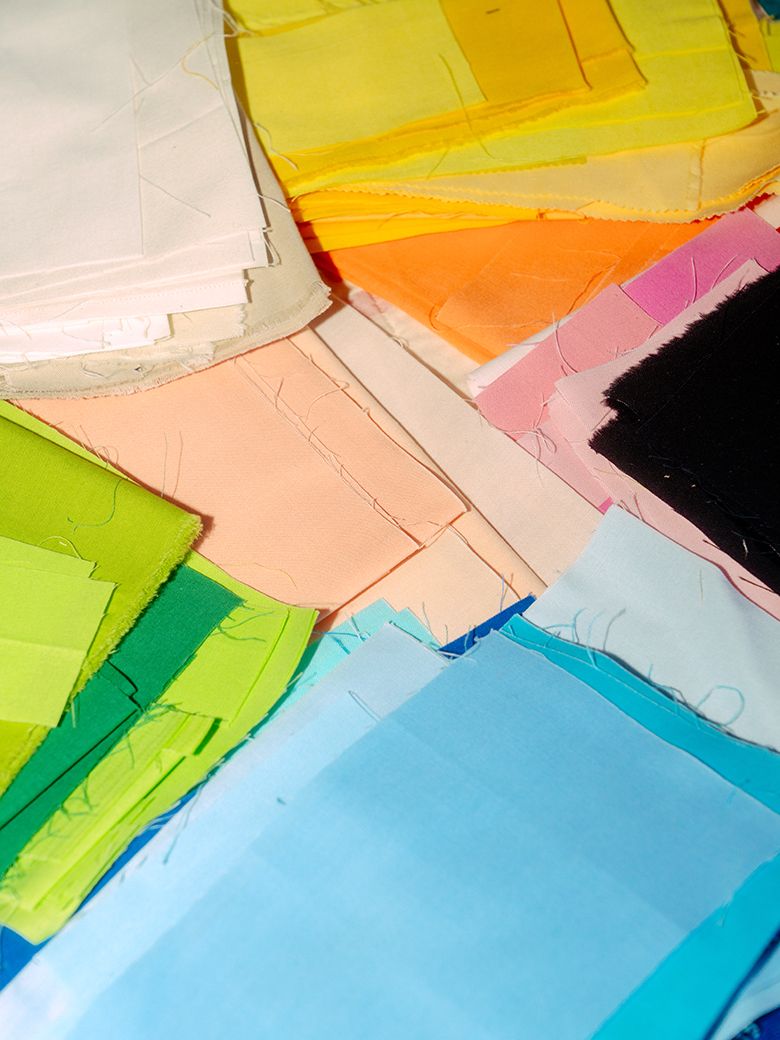A photograph of fabric swatches stacked on the bed. 