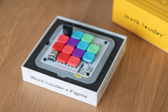 The Figma Creator Micro keyboard sitting in its box on a desk.
