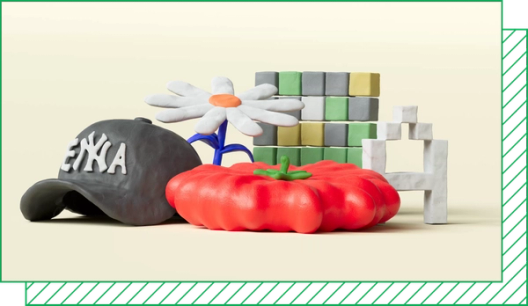 A tableau of clay objects: a baseball cap reading “Enya,” a daisy, a tomato, a Wordle grid, and a pixelated letter A