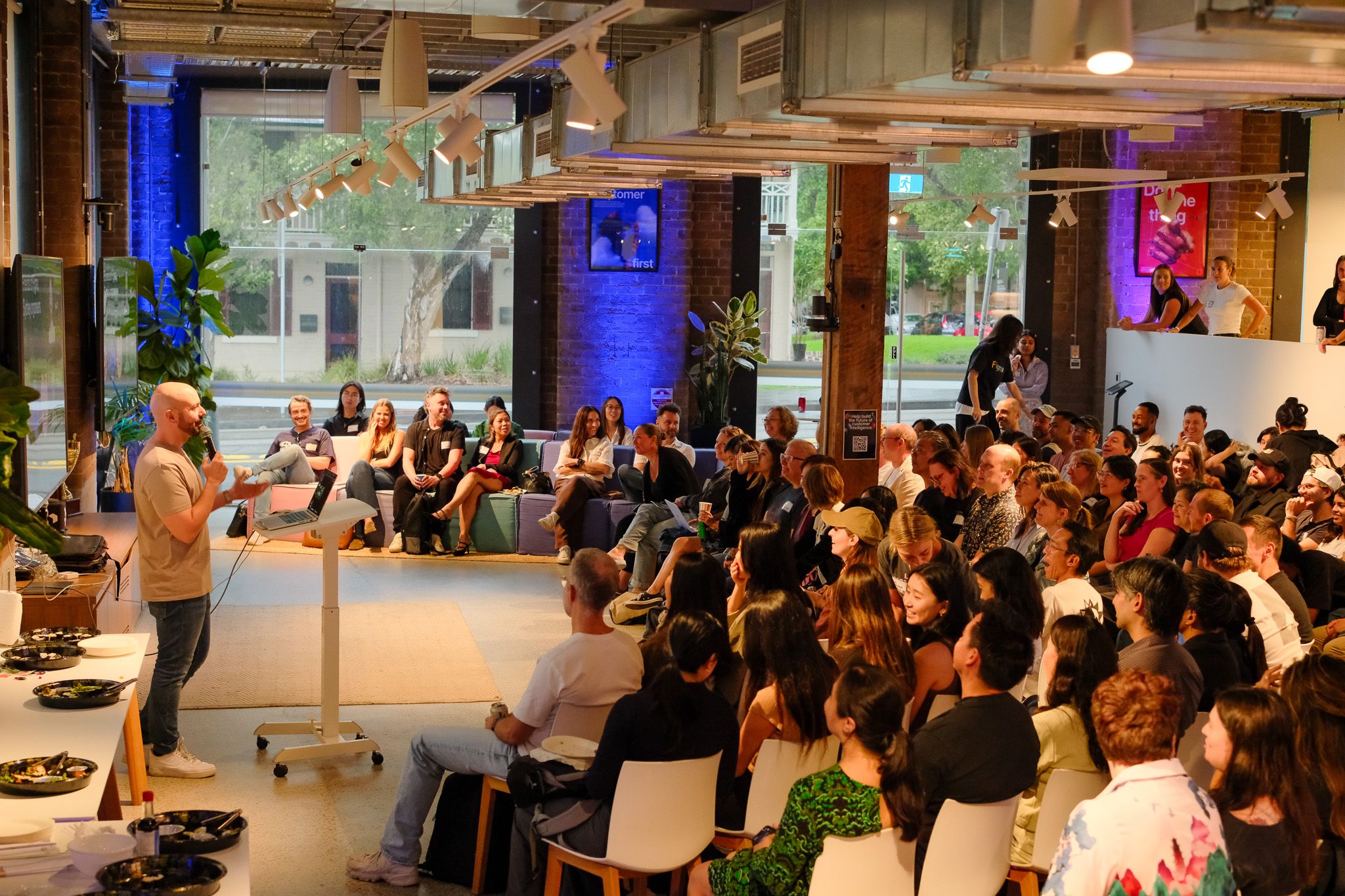 Attendees watch presenter speak in front of a podium