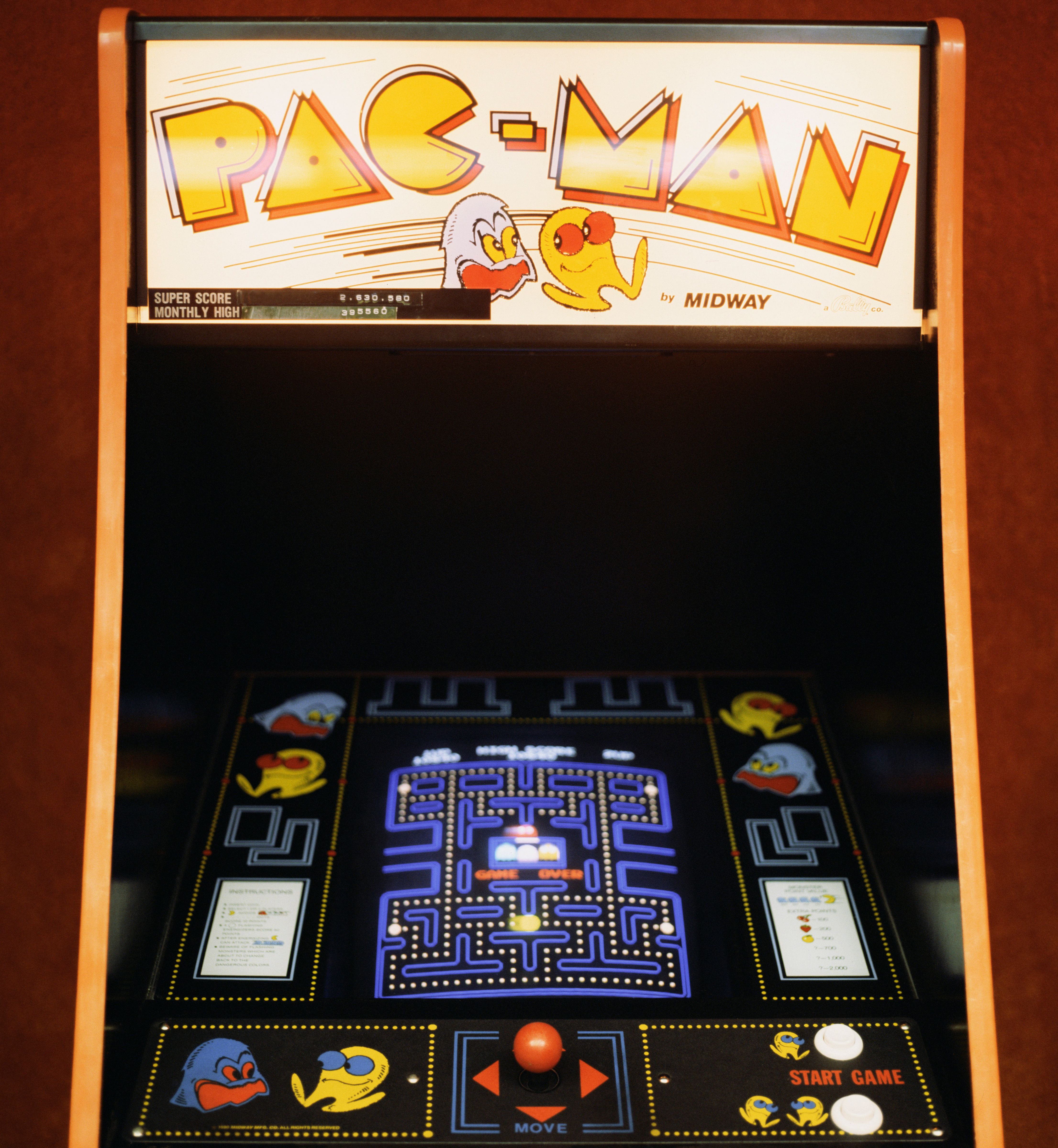 A vintage Pac-Man arcade machine with the game screen visible.