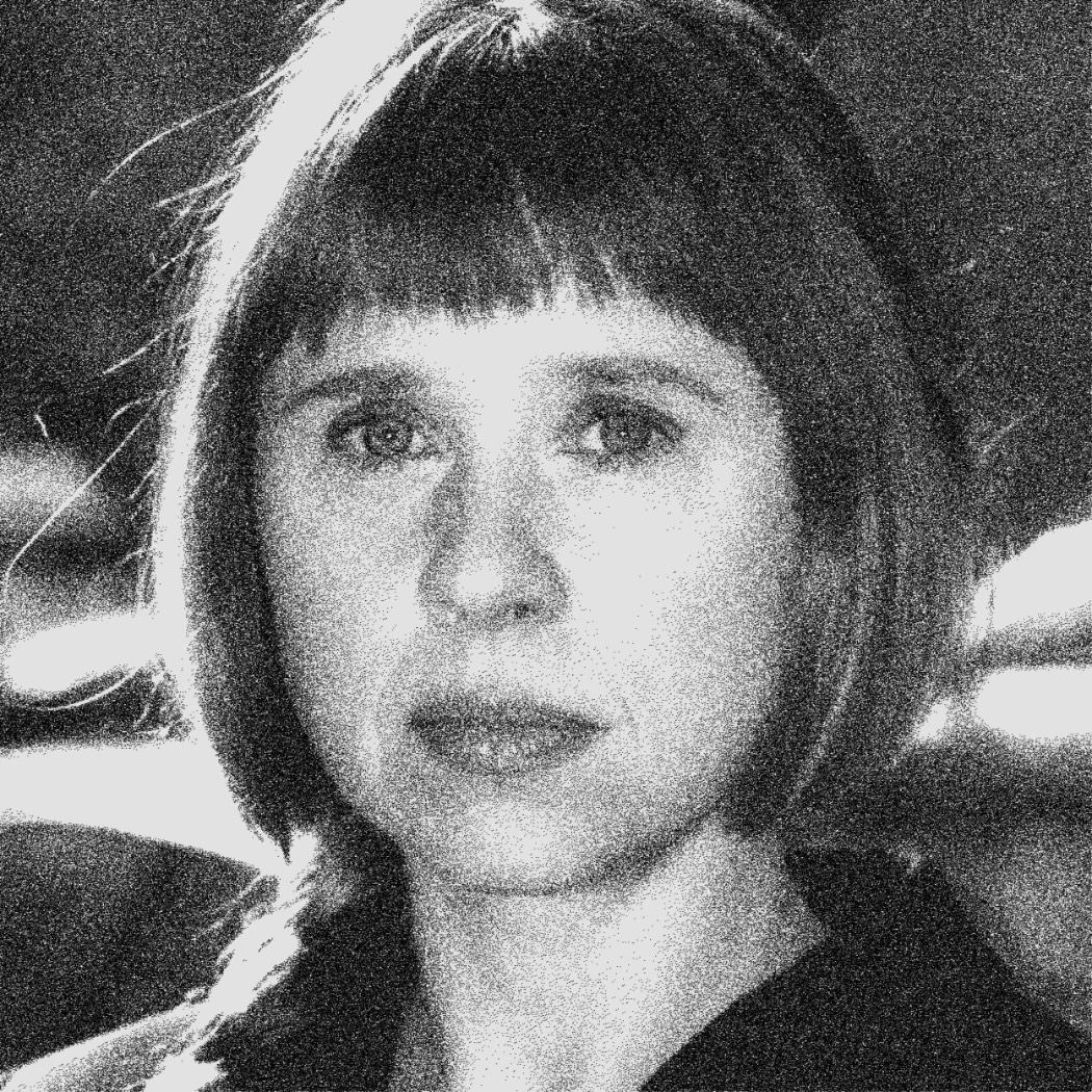Woman with short bob haircut and bangs, serious expression, black and white portrait indoors setting
