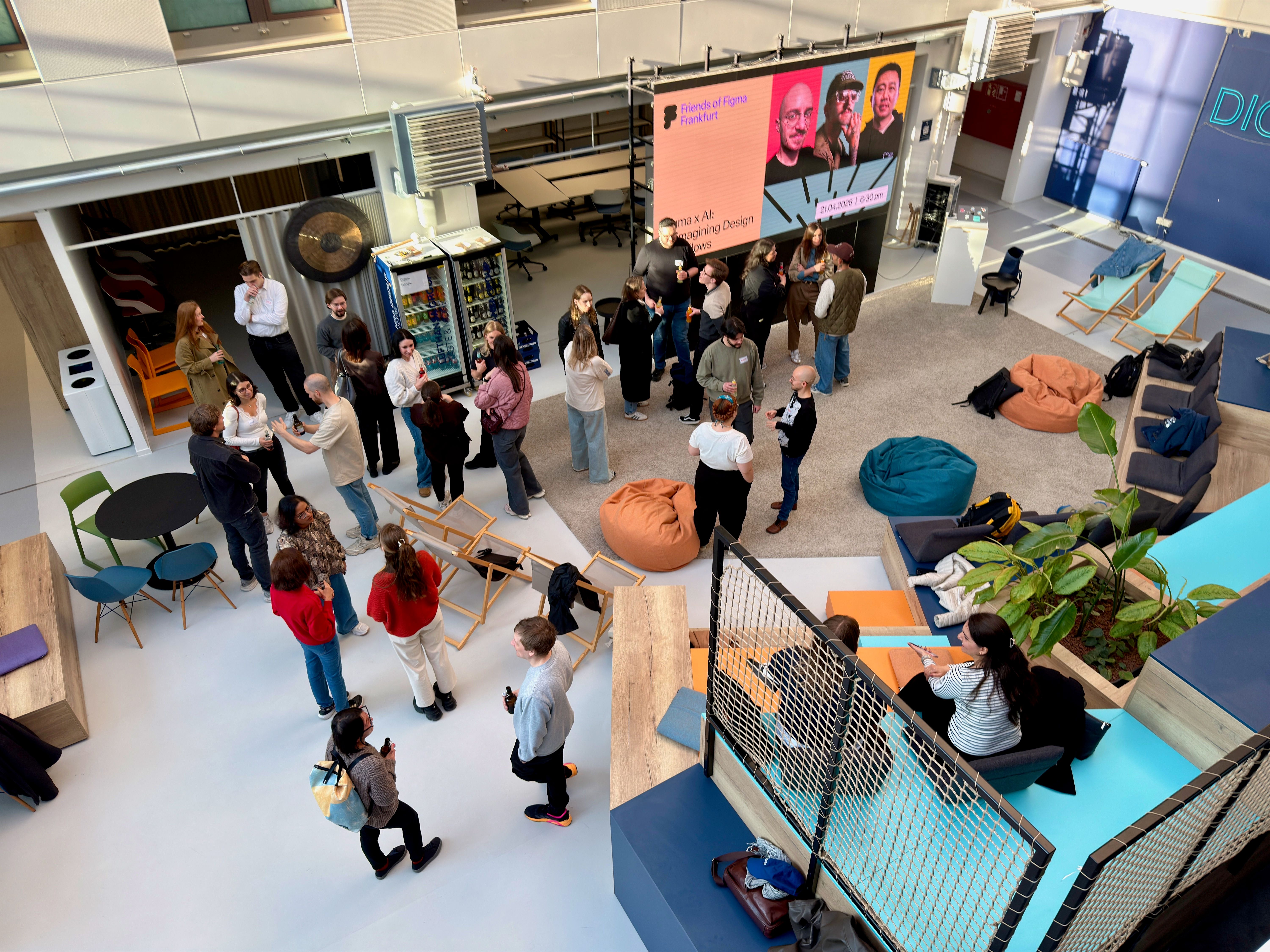 Attendees shot from above talk to each other in a bright venue at an event