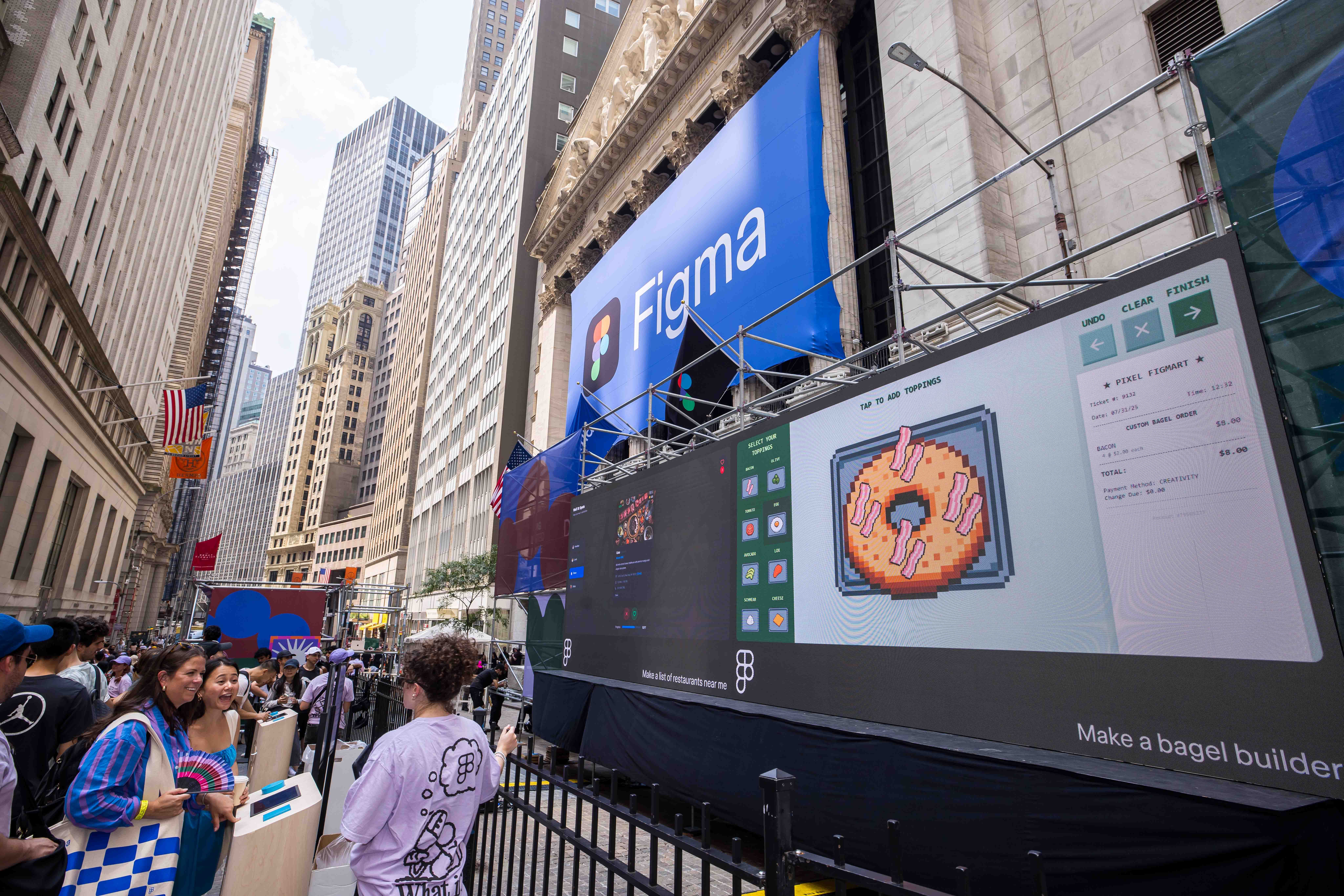Attendees interact with a large touchscreen showing a Figma interface below a branded banner.